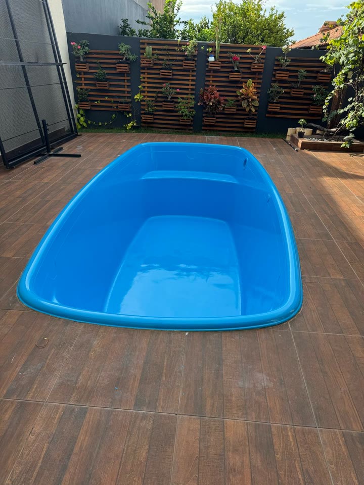 Depois: a mesma piscina de fibra reformada, com o azul novo
