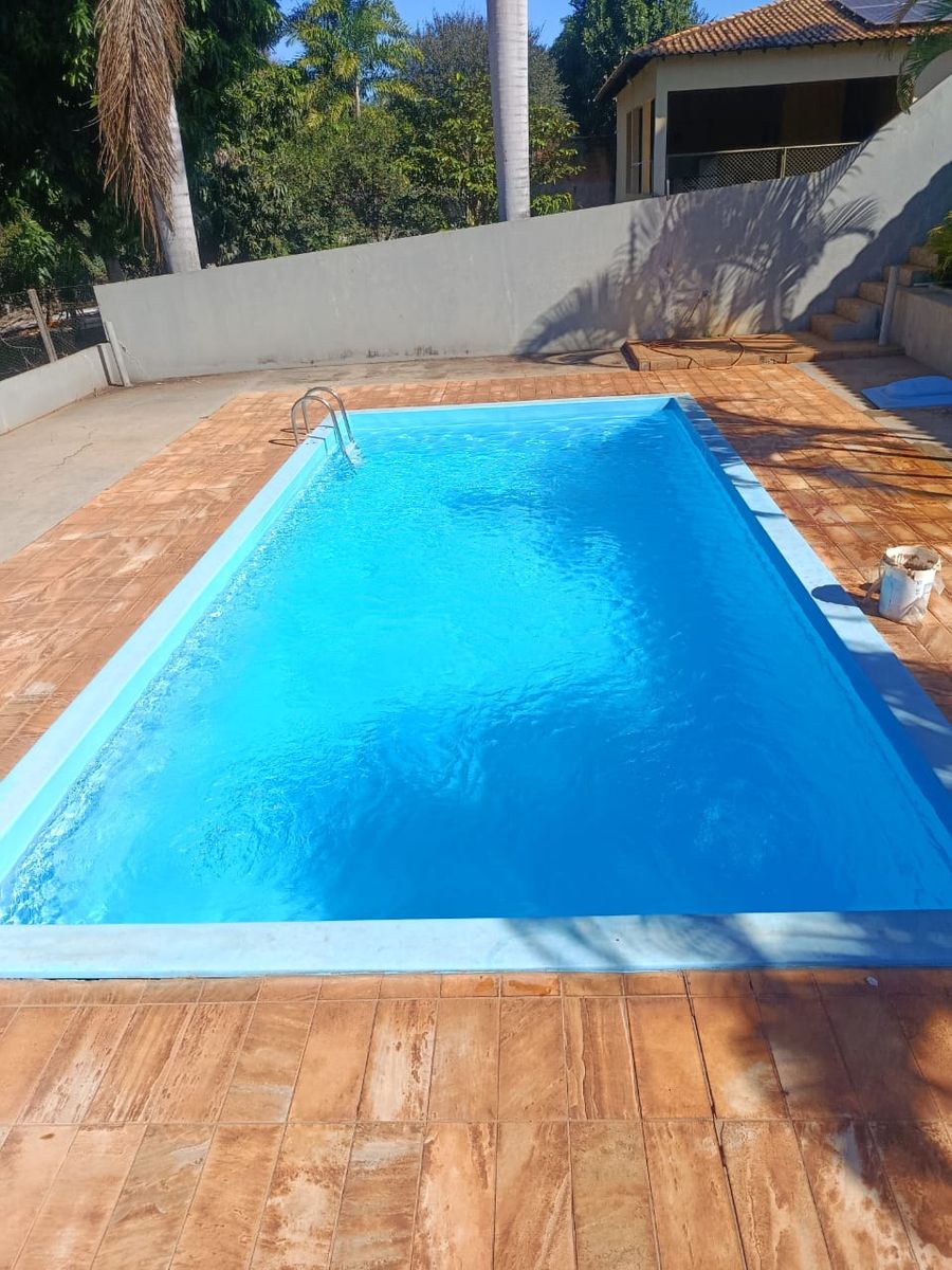 Piscina azul com deck de pedra, pronta para usar