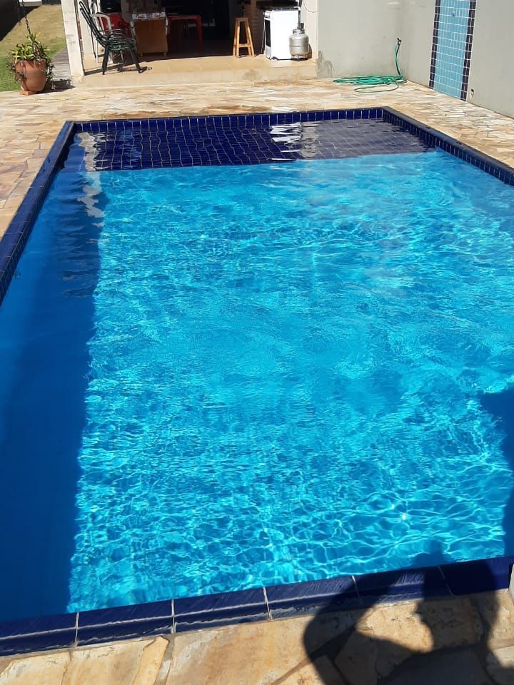 Piscina de pastilha azul em área de lazer, com a casa de máquinas revisada